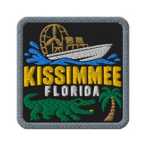 May include: A square embroidered patch with a black background and a grey border. It features a white airboat with a tan fan, blue water splashes, the yellow text KISSIMMEE, white text FLORIDA, a green alligator, and a small green palm tree.