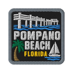May include: A square embroidered patch with a black background and a grey border. It features a white pier over blue waves, a green palm tree with a brown trunk, a white sailboat, and the white text POMPANO BEACH with yellow FLORIDA text.