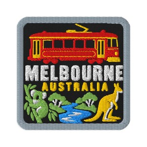 Peut inclure: Un écusson brodé carré avec une bordure grise sur fond noir. Il présente un tramway rouge et jaune au-dessus du texte blanc MELBOURNE et du texte jaune AUSTRALIA. En dessous, un koala vert dans un arbre, une rivière bleue et un kangourou jaune.