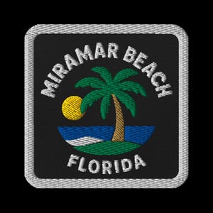 May include: Embroidered patch with the text "Miramar Beach Florida" encircling a palm tree, sun, and ocean design. The patch is square, with a white border and a black background.