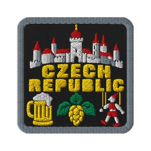 May include: A square embroidered patch with a black background and a gray border. It features a white and red castle, the yellow text CZECH REPUBLIC, a yellow beer mug with white foam, a green hop cone, and a small red and white marionette figure.