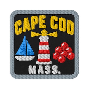 May include: A square embroidered patch with a black background and a grey border. It features the yellow text CAPE COD above a blue sailboat, a red and white lighthouse, and a cluster of red cranberries, with the white text MASS. below.