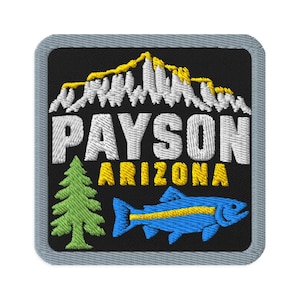 May include: A square embroidered patch with a black background and a gray border. It features a white and yellow mountain range above the white text PAYSON and yellow text ARIZONA, with a green pine tree and a blue fish with a yellow stripe.