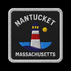 Puede incluir: Parche bordado con un faro de rayas rojas y blancas, un sol amarillo y el texto "NANTUCKET MASSACHUSETTS" en blanco sobre un fondo negro. El parche tiene un borde blanco.