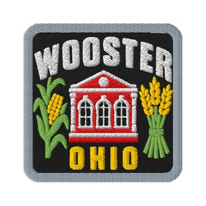 Pode incluir: Um emblema bordado quadrado com borda cinza sobre fundo preto. Apresenta o texto branco WOOSTER no topo e o texto amarelo OHIO na parte inferior. Um edifício vermelho com detalhes brancos fica entre uma espiga de milho verde e trigo amarelo.