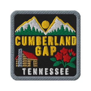 May include: A square embroidered patch with a black background featuring a yellow sun, white mountains, and green pine trees. It displays the yellow text CUMBERLAND GAP, a log cabin with a red roof, and red flowers, with white TENNESSEE text below.