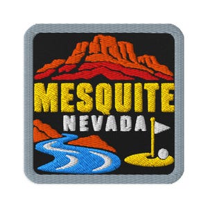 May include: A square embroidered patch with a gray border featuring a black background, orange desert mountains, a blue winding river, and a yellow golf flag with a white ball. The text reads MESQUITE in yellow and NEVADA in white letters.