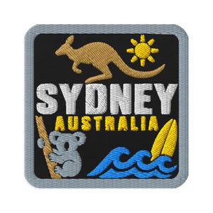 Peut inclure: Un écusson brodé carré avec un fond noir et une bordure grise. Il présente un kangourou beige, un soleil jaune, le texte blanc SYDNEY, le texte jaune AUSTRALIA, un koala gris sur une branche, une planche de surf jaune et des vagues bleues.