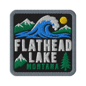 May include: A square embroidered patch with a black background featuring a large blue wave, green mountains with white snow caps, a yellow sun, and a green pine tree. The text reads FLATHEAD LAKE in white and MONTANA in green.
