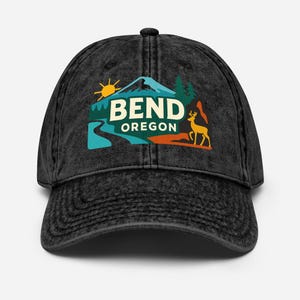 Op de afbeelding: Zwarte baseball cap met een verweerde uitstraling. De cap heeft een kleurrijke afbeelding van een berg, rivier, zon, bomen en een hert, met de tekst "BEND OREGON" in wit en groen.