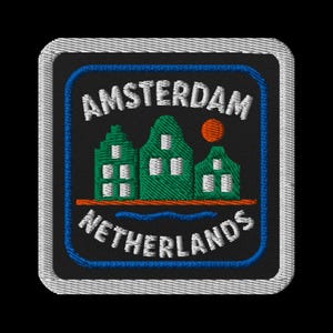 May include: Embroidered patch featuring the text "AMSTERDAM NETHERLANDS" in white. The design includes green houses, an orange sun, and a blue border on a black background. The patch has a white border.
