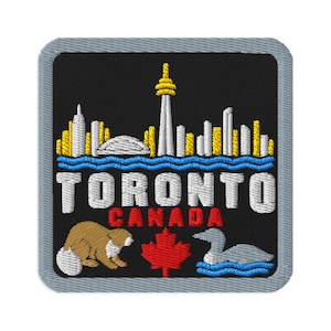 May include: A square embroidered patch with a black background featuring a white and yellow Toronto skyline above blue water. The text TORONTO CANADA is stitched in white and red. Below, a brown beaver, a red maple leaf, and a grey loon appear.