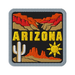 Peut inclure: Un écusson brodé carré avec une bordure grise sur fond noir. Le motif représente un paysage désertique avec des formations rocheuses rouges et beiges, un cactus saguaro blanc, un soleil jaune et le mot ARIZONA en lettres jaunes.