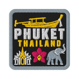 Op de afbeelding: Een vierkante geborduurde patch met een zwarte achtergrond en een grijze rand. Het toont een gele longtailboot, de witte tekst PHUKET, gele tekst THAILAND, een wit-gele tempel, een roze orchidee en een illustratie van een grijze olifant.
