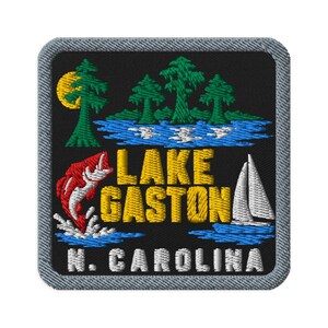 May include: A square embroidered patch with a black background featuring a yellow sun, green trees, blue water, a red jumping fish, and a white sailboat. The text reads LAKE GASTON in yellow and N. CAROLINA in white, all bordered by a grey stitched edge.