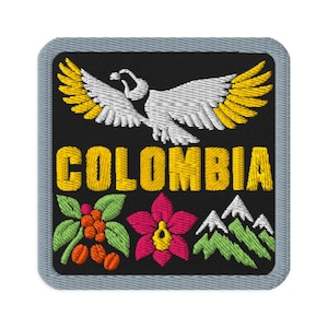 May include: A square embroidered patch with a gray border on a black background. It features a white and yellow bird with wings spread, the word COLOMBIA in yellow text, a coffee plant branch, a pink orchid, and green mountain peaks.