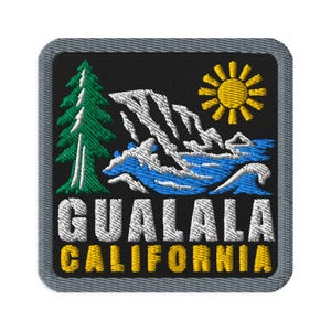 May include: A square embroidered patch with a black background and a gray border. The design features a green pine tree, white mountain peaks, a blue ocean wave, and a yellow sun. The text GUALALA CALIFORNIA is embroidered in white and yellow.
