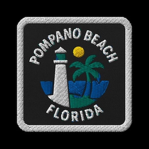 May include: Embroidered patch featuring a lighthouse, palm tree, and sun, with the words "Pompano Beach Florida" in white lettering on a black background. The patch has a white stitched border.