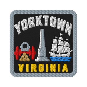 Op de afbeelding: Een vierkante geborduurde patch met een zwarte achtergrond en een grijze rand. Het bevat de witte tekst YORKTOWN in een boog aan de bovenkant en VIRGINIA in het geel aan de onderkant. Het ontwerp bevat een rood kanon, gouden kanonskogels, een grijs monument en een wit zeilschip op blauwe golven.