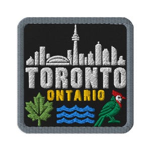 Puede incluir: Un parche bordado cuadrado con fondo negro y borde gris. Presenta un horizonte blanco de Toronto, el texto TORONTO ONTARIO en blanco y amarillo, una hoja de arce verde, olas azules y una ilustración de un pájaro de color verde y rojo.