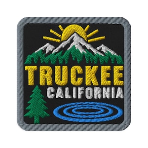 May include: A square embroidered patch with a black background and a gray border. It features a yellow sun rising over white snow-capped mountains and green pine trees. The text TRUCKEE is in yellow and CALIFORNIA is in white, with a blue lake.