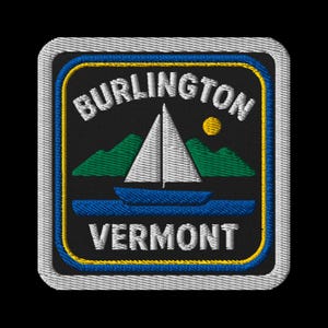 May include: Embroidered patch with "BURLINGTON VERMONT" text, a sailboat on blue water, green mountains, and a yellow sun on a black background. It has a blue, yellow, and white border. The design is square-shaped.