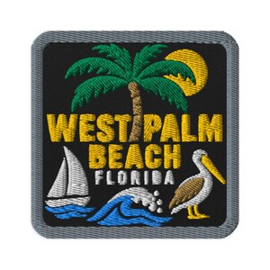 Puede incluir: Un parche bordado cuadrado con fondo negro y borde gris. Presenta una palmera verde, un sol amarillo, un velero blanco sobre olas azules, un pelícano marrón y blanco, y el texto amarillo WEST PALM BEACH FLORIDA.