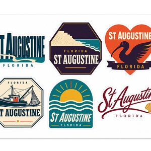 May include: A collection of six St. Augustine, Florida themed stickers. Designs include a dark blue text logo, a hexagonal beach scene, a heart-shaped ibis bird graphic, a fishing boat in an octagon, a sunset over waves, and a script logo with a shell.