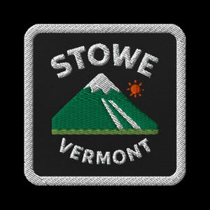 May include: Embroidered patch featuring the text "STOWE VERMONT" in white, arched above and below a green mountain with white snow and two white ski slopes. A small orange sun is to the right of the mountain. The patch has a black background and a white border.