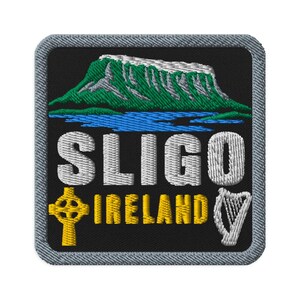 May include: A square embroidered patch with a black background featuring a green and white mountain above a blue lake. The text SLIGO is in white, and IRELAND is in yellow. A yellow Celtic cross and a white harp are on the bottom corners.