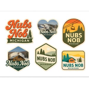 May include: A collection of six colorful stickers featuring the text "Nubs Nob Michigan" in various designs. The stickers showcase ski resort imagery, including a ski lift, mountain scenes, and a cabin.