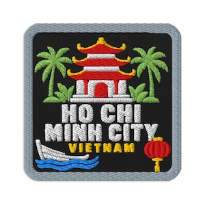 Op de afbeelding: Een vierkante geborduurde patch met een grijze rand op een zwarte achtergrond. Het toont een rood-witte pagode, groene palmbomen, een witte boot op blauwe golven en een rode lantaarn. De tekst luidt HO CHI MINH CITY VIETNAM in wit en geel.