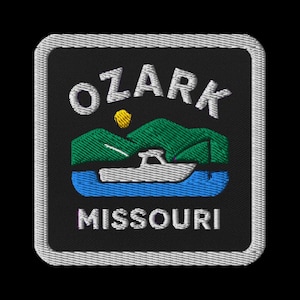 Puede incluir: Parche bordado con el texto "OZARK MISSOURI". El diseño incluye un barco sobre agua azul, colinas verdes y un sol amarillo. El parche tiene un fondo negro y un borde blanco.