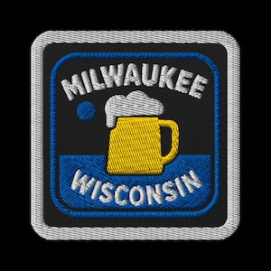 May include: Embroidered patch with a yellow beer mug and white foam on a blue and black background. The words "MILWAUKEE" and "WISCONSIN" are arched above and below the mug in white. The patch has a white border.