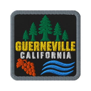 May include: A square embroidered patch with a black background and a gray border. It features five green pine trees above the yellow text GUERNEVILLE and white text CALIFORNIA. Below the text are orange grapes and three blue wavy lines.