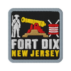 Puede incluir: Un parche bordado cuadrado con borde gris sobre fondo negro. Presenta un soldado blanco, un cañón amarillo sobre una base color canela y un tambor rojo y blanco. El texto dice FORT DIX en blanco y NEW JERSEY en letras amarillas.