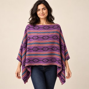 May include: A purple poncho featuring a horizontal pattern of dark diamond shapes and thin stripes in shades of blue, red, and orange. The garment has a wide boat neckline and a loose, draped fit that extends to the mid-thigh area.