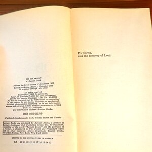 May include: Open book with text from "THE GOD PROJECT" by John Saul. The book is a Bantam hardcover edition from September 1982. The text includes copyright information, ISBN, and the publisher's address in New York.