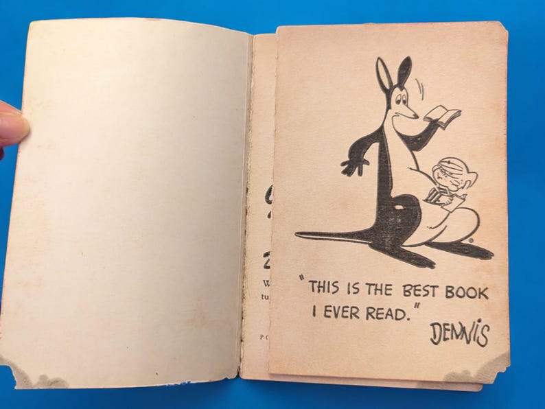 May include: An open book with a black and white illustration of a kangaroo reading a book to a small child. The text on the page reads "This is the best book I ever read."  Dennis.