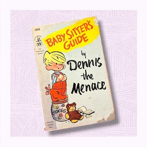 May include: A vintage paperback book titled "Baby Sitter's Guide by Dennis the Menace". The cover features a cartoon illustration of Dennis the Menace standing on a cookie jar with a teddy bear and a book on the floor.