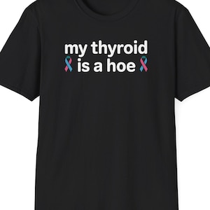 May include: Black t-shirt with the text "my thyroid is a hoe" in white, with teal and pink ribbon graphics. The shirt is a basic crew neck style.