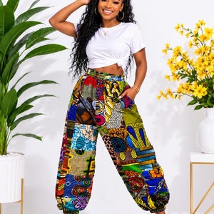 May include: A white short-sleeved t-shirt with a knotted hem paired with loose-fitting, high-waisted pants featuring a vibrant, multi-colored patchwork pattern of various geometric and floral prints in shades of blue, yellow, red, and green.