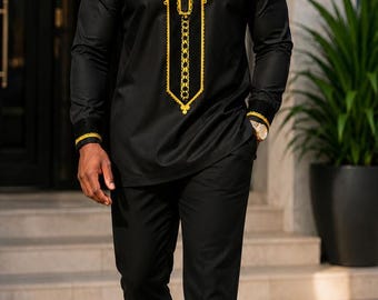 May include: A black long-sleeved tunic featuring a round neckline and a vertical chest panel adorned with intricate gold embroidery. The tunic is paired with matching black trousers and black dress shoes, creating a coordinated ensemble.