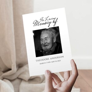 May include: Black and white photograph memorial card with the text "In Loving Memory of" and a photo of a man with a beard and moustache. The text "Theodore Anderson" and the dates "March 7, 1939 - May 10, 2023" are printed below the photo.