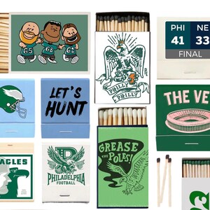 May include: A collection of matchboxes with various Philadelphia Eagles-themed designs. The boxes feature illustrations of the team's logo, players, and stadium, along with phrases like "Let's Hunt" and "Grease the Poles!" The color scheme includes green, blue, and white.