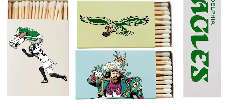 May include: Matchboxes with various designs. One features football players, another an eagle with a football, and a third depicts a man in ornate attire. The fourth box displays the word "Eagles" in green.