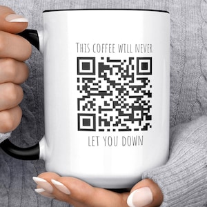 May include: White ceramic coffee mug with a black rim and handle. The mug has a black and white QR code with the text "This coffee will never let you down".