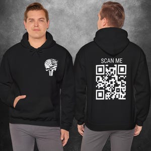 May include: Black hooded sweatshirt with a white skull graphic on the front and a white QR code with the text "SCAN ME" on the back.