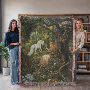 Peut inclure: Une tapisserie repr&eacute;sentant une licorne blanche et une femme lisant un livre dans un d&eacute;cor de for&ecirc;t. La tapisserie est de couleur verte, marron et rose avec des d&eacute;tails floraux.