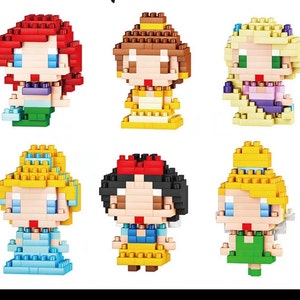 May include: A set of six mini block figures of Disney princesses. The princesses are Ariel, Belle, Rapunzel, Cinderella, Snow White, and Tiana. Each figure is made of colourful plastic blocks and has a unique design.